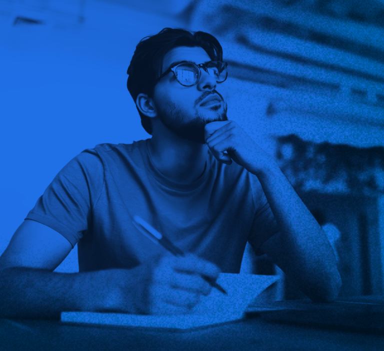 Man considering DAM data security factors while writing notes in a notebook