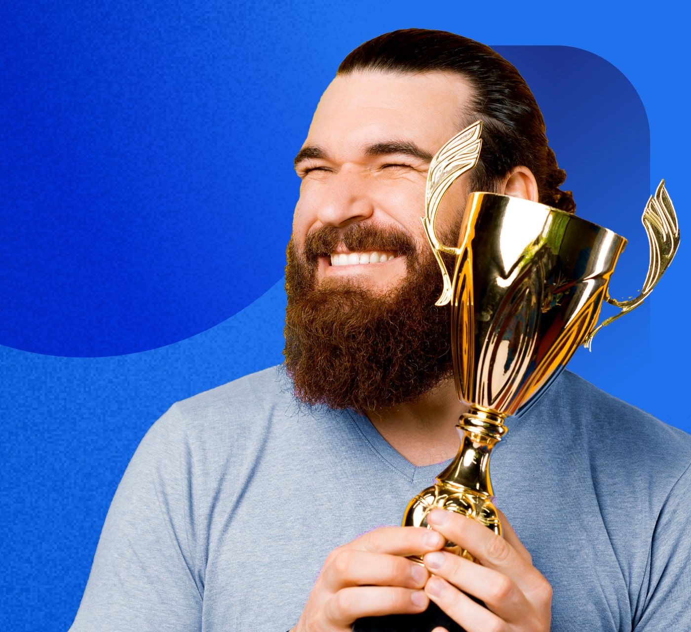 a man holding a trophy and smiling with a blue background