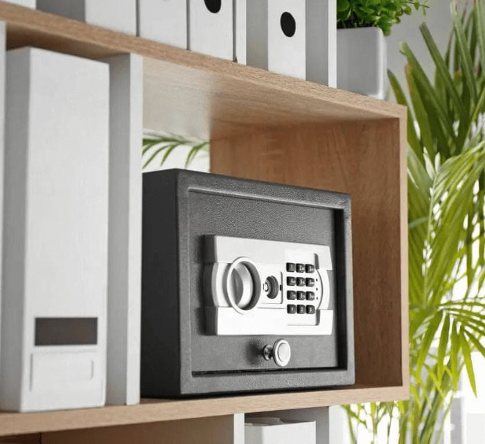 A black safe on a wooden shelf