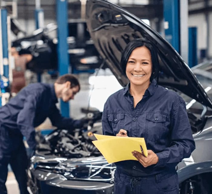 A woman holding a folder while working at an autobody center