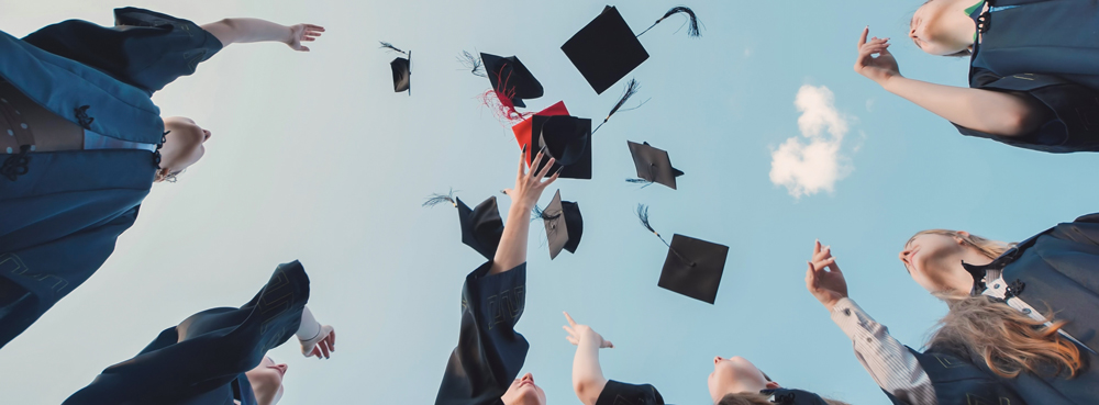 graduation students throwing their graduation caps