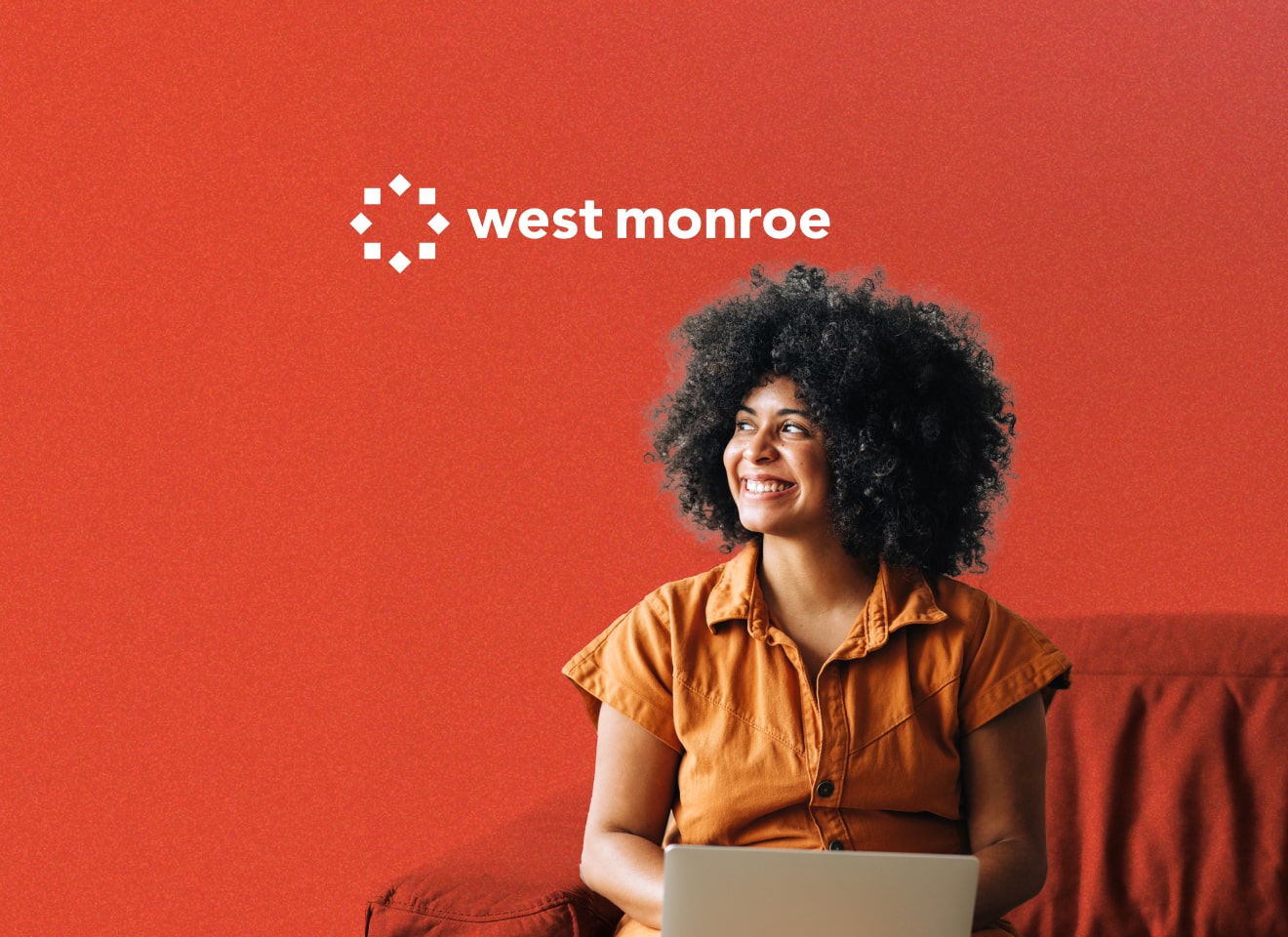 Girl with a laptop on her lap looking up at the West Monroe logo.