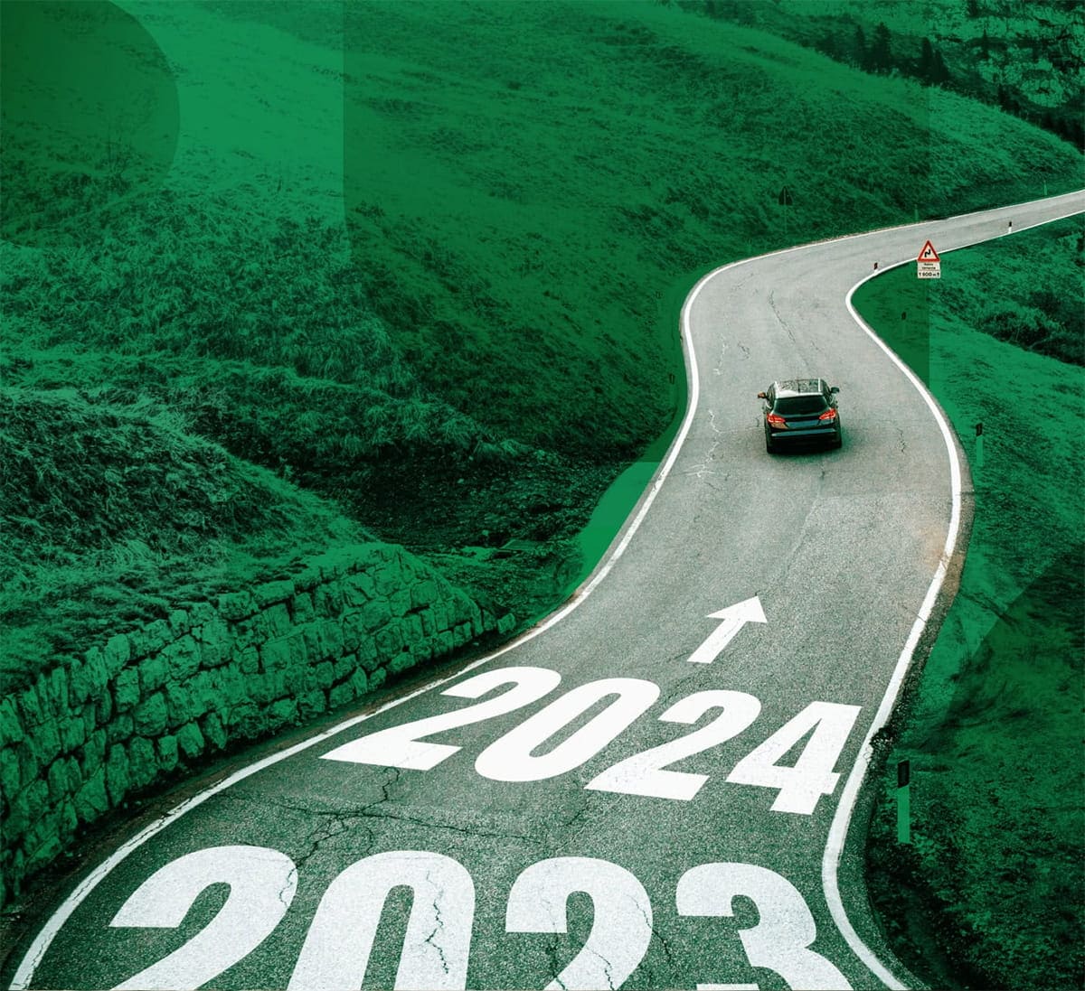 Car driving down a winding road with 2024 marked on the roadway