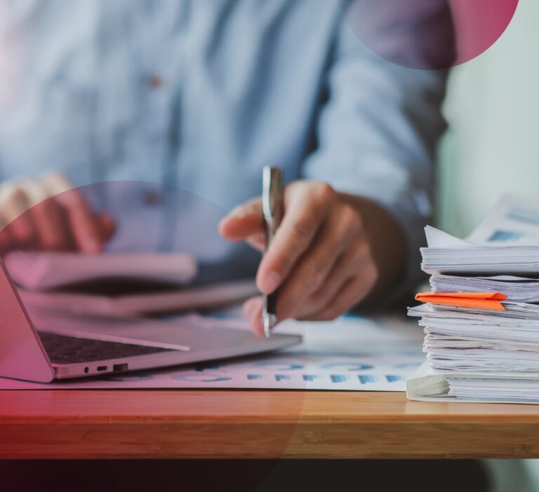 Man in a blue shirt with a pen in his hand writing notes about how to maintain brand during an M&A
