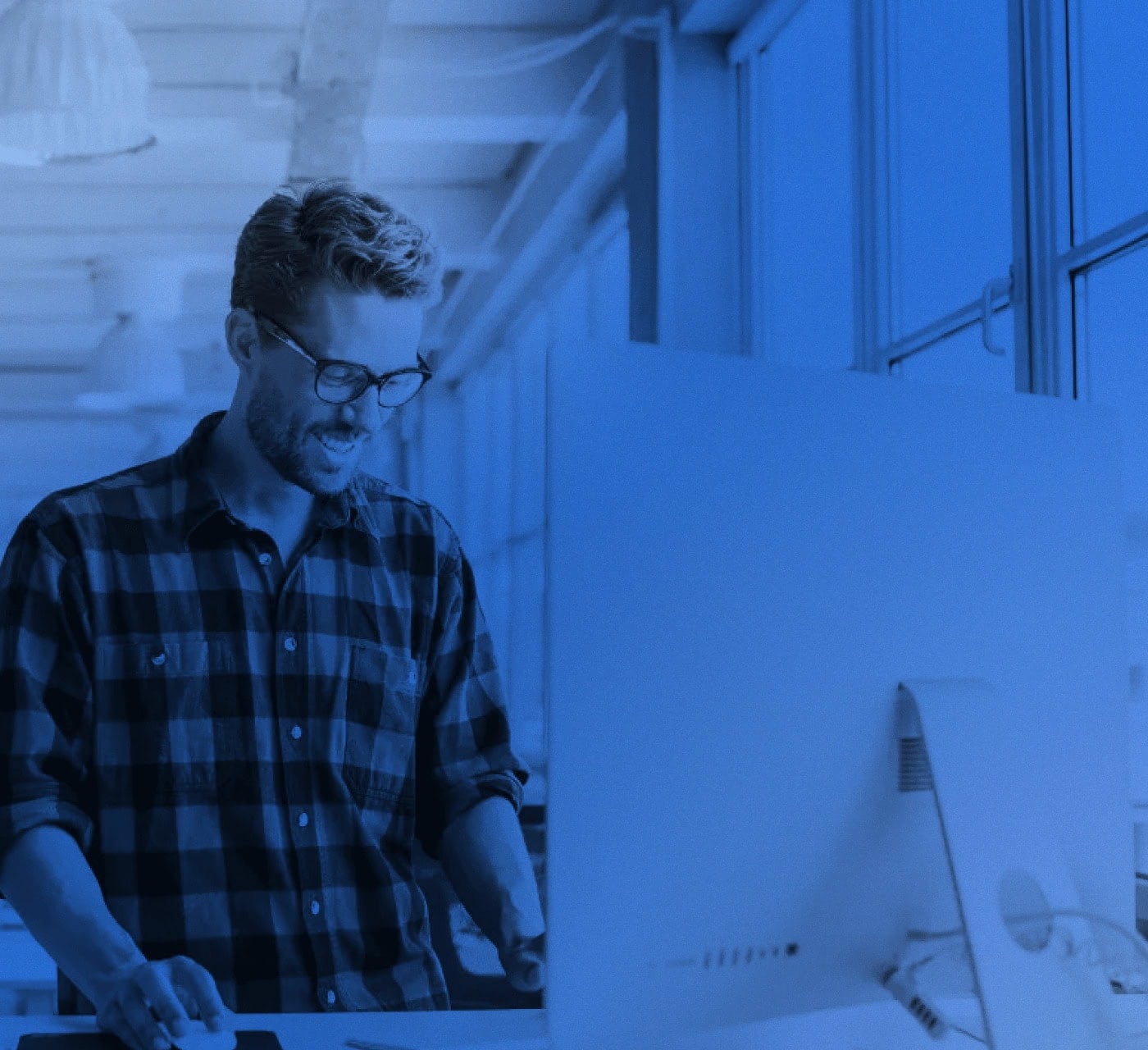 a man in glasses working on his desktop