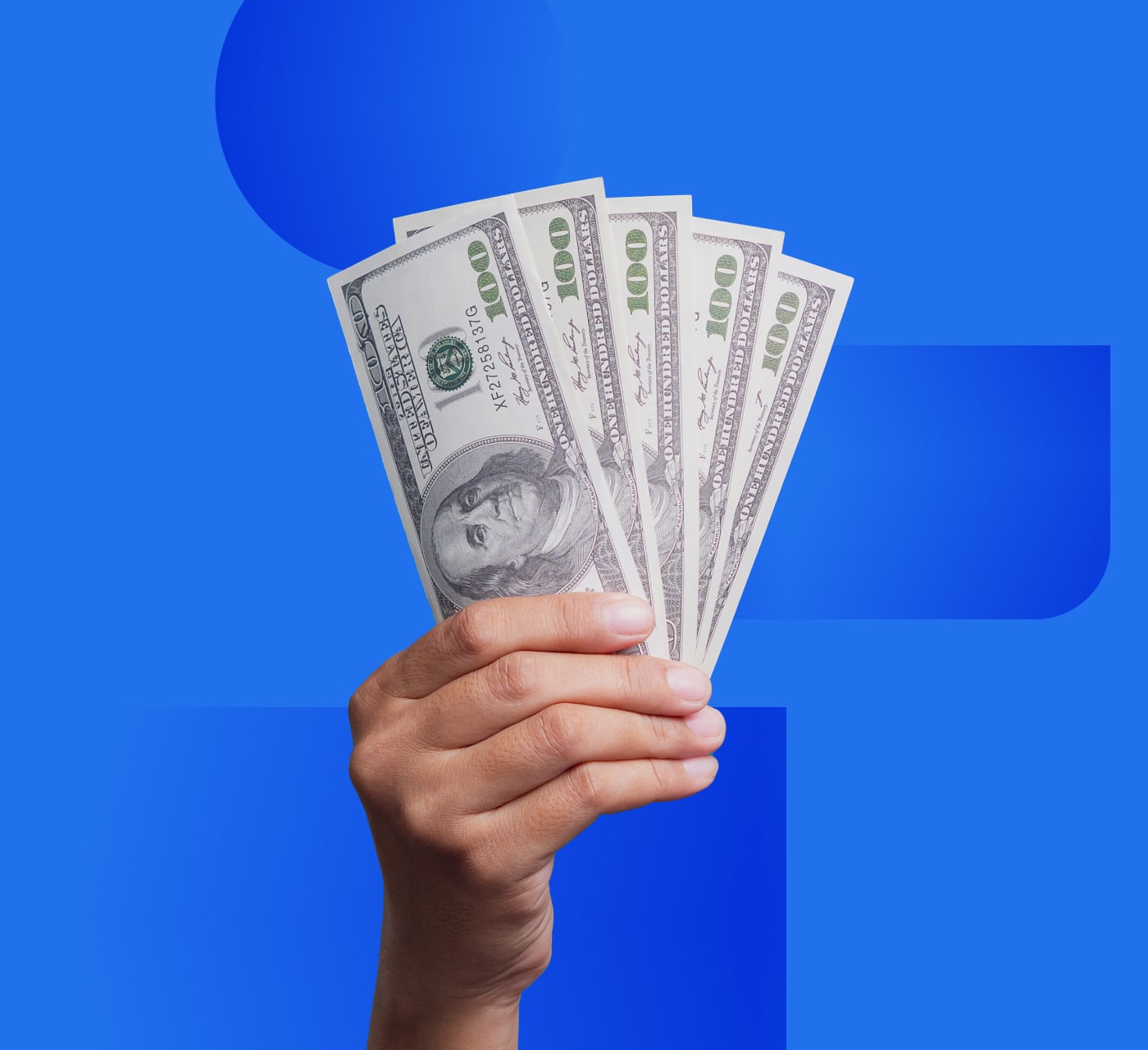 White hand holding up several dollar bills on a blue background