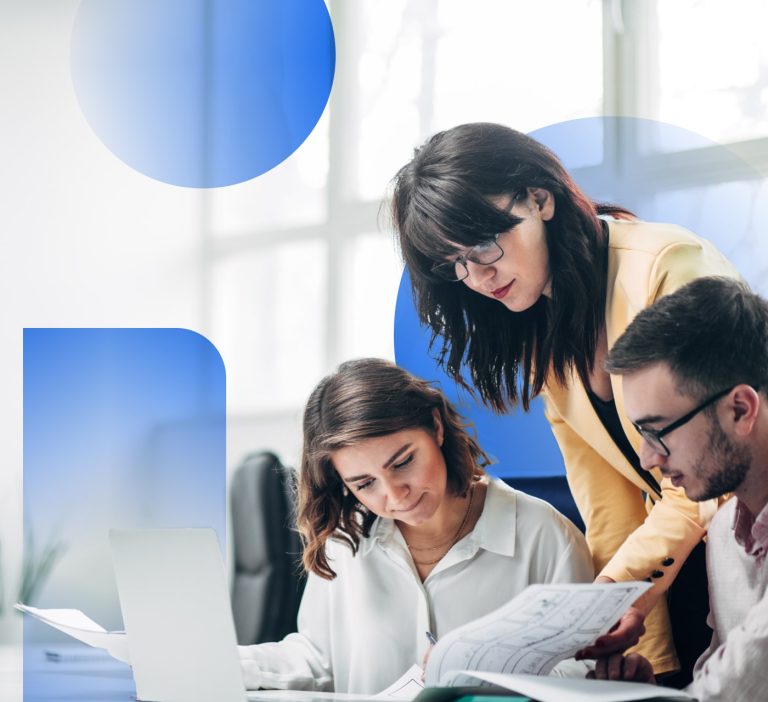 group of three people, one in a white shirt, another in a peach coloured jacket, and the third wearing glasses, gathered around a desk looking at a notebook. Blue shapes are overlayed on the image.