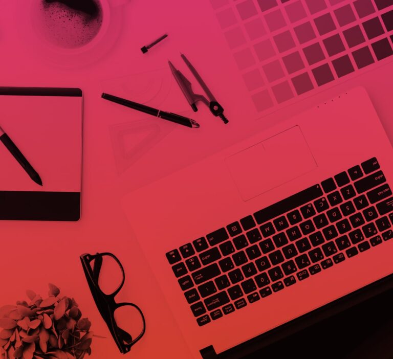 Table with a laptop, keyboard, reading glasses and pens on top with a pink overlay.