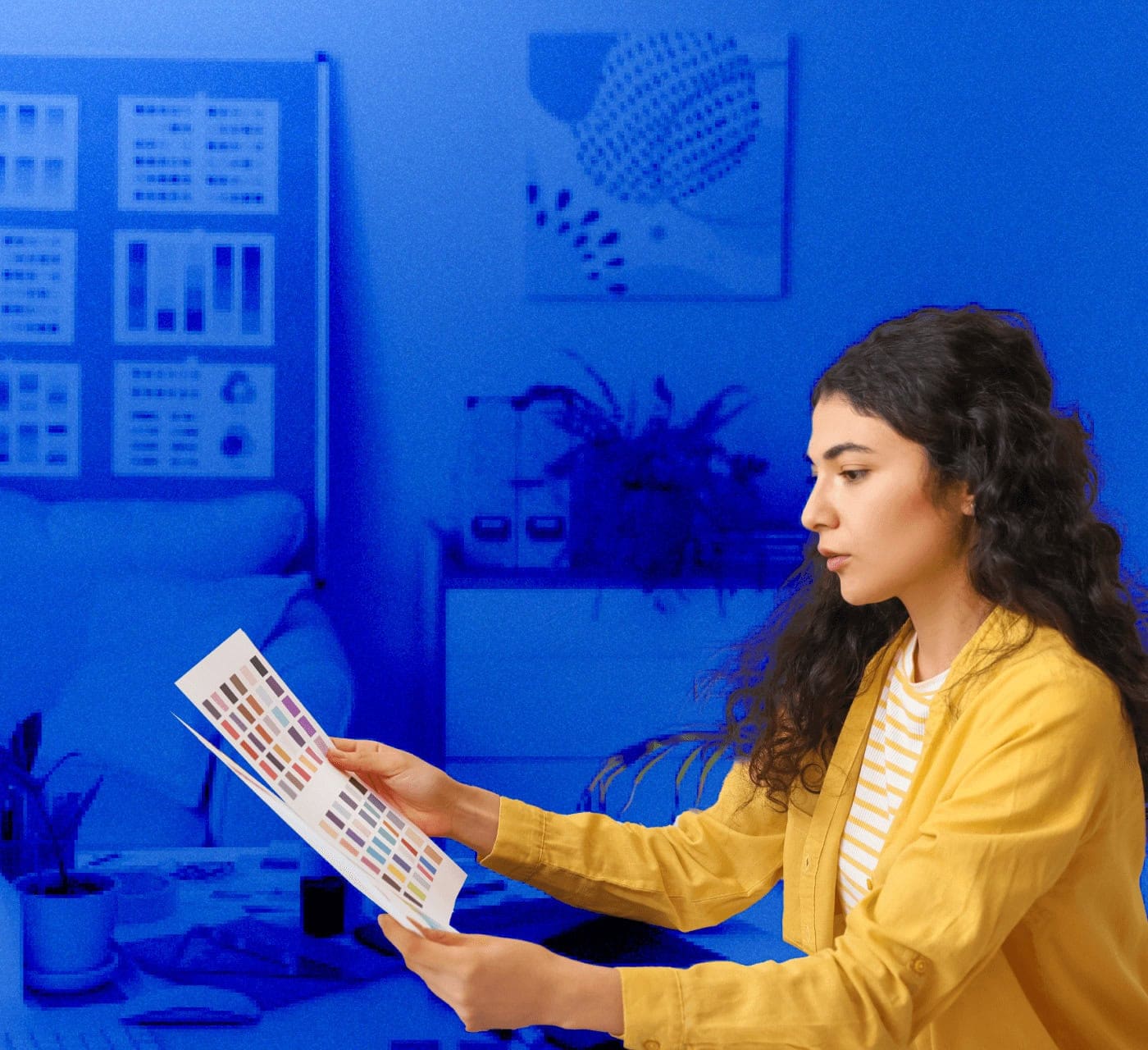 woman looking a colors in her studio on a blue background