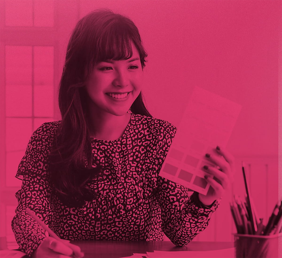 Smiling female graphic designer with a color swatch sheet in her hand