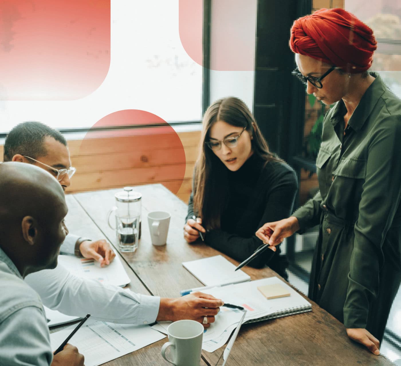 team discussing documents on a desk against a white and red background