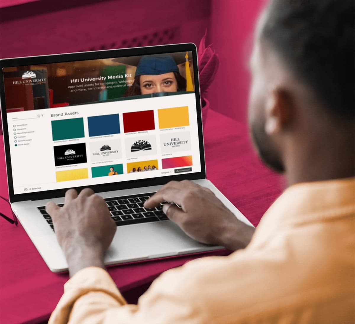 Business man on a laptop looking at a brand portal for Hill University