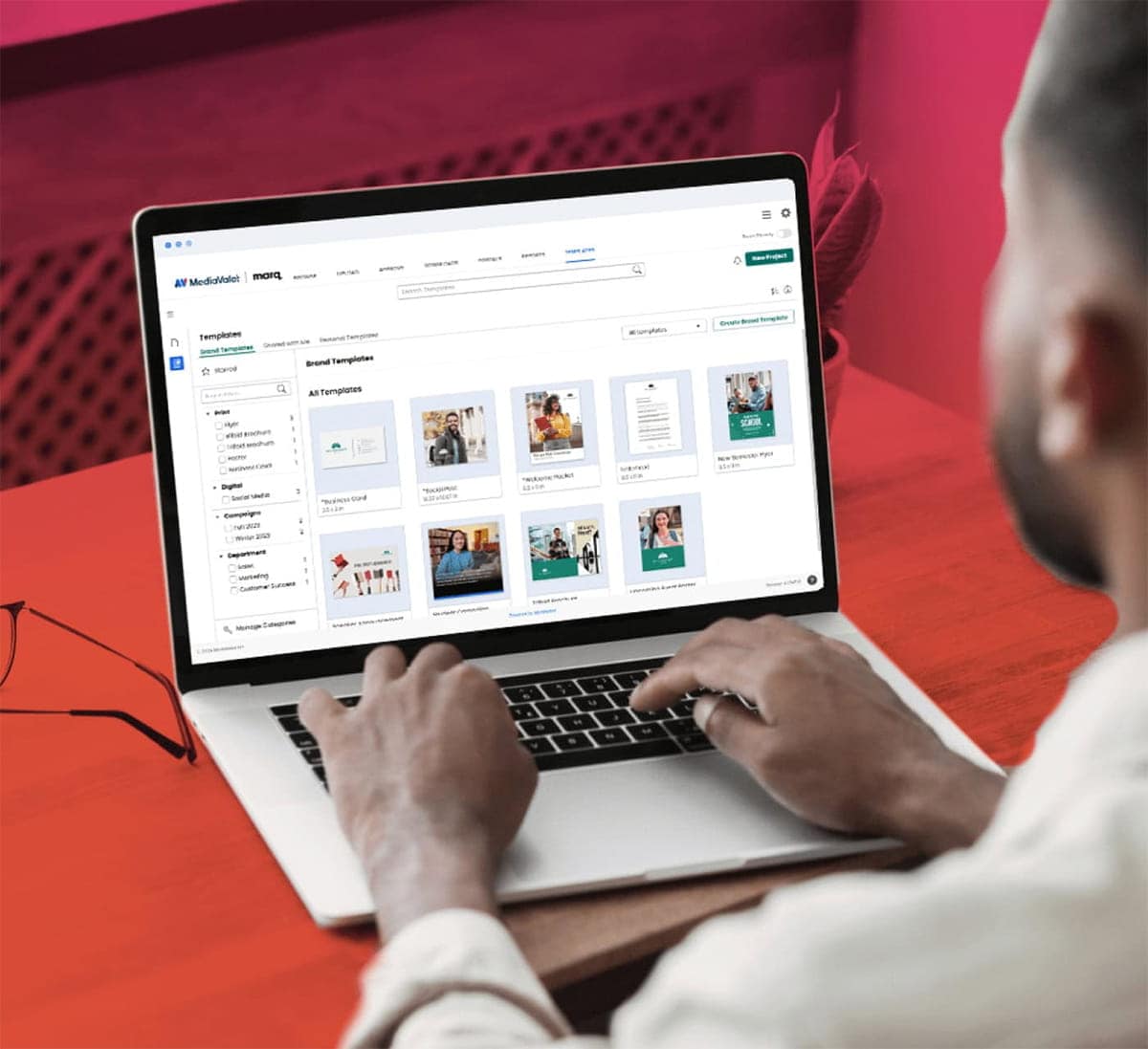 Business man working on a laptop, the screens shows MediaValet templating software