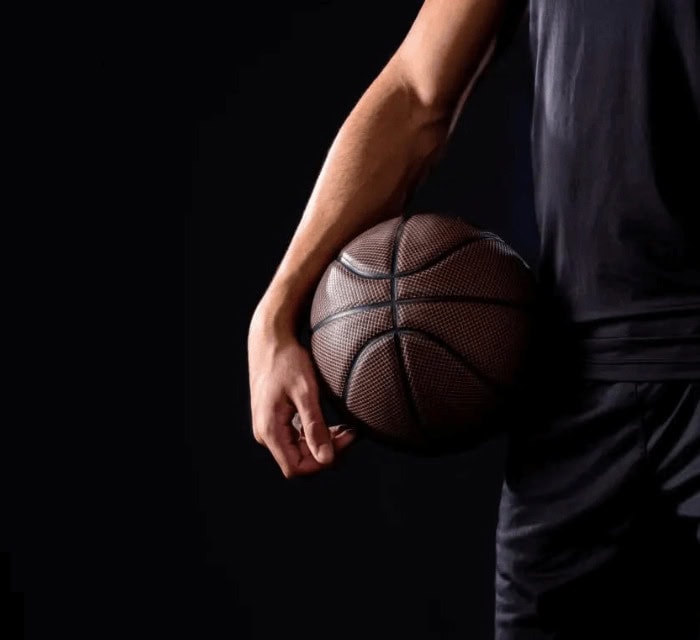Someone holding a basketball near their hip